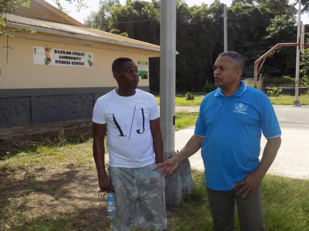 Contractor and Basilon Street resident Reynold Rosal, left, speaks with Supt Wayne Mohammed of the Inter Agency Task Force at the Basilon Street Community Centre yesterday. 