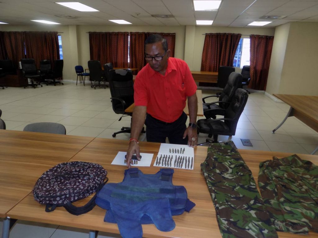 Snr Supt of the Inter Agency Task Force points to a bullet proof vest seized during a police exercise yesterday in Sea Lots.