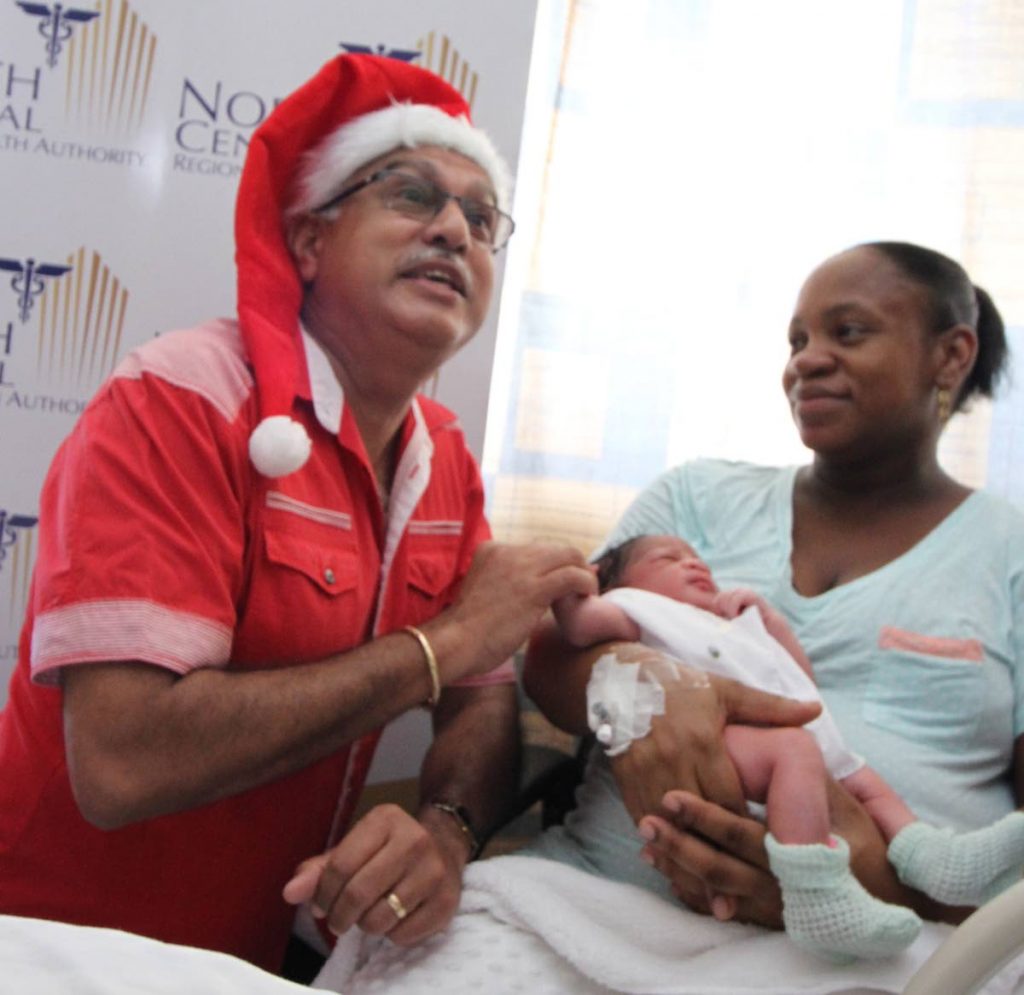 GIVE HIM MY NAME: Health Minister Terrence Deyalsingh as he exhorts Jenise Guerra to name her newborn son after him. The minister met and congratulated several Christmas Day mothers at the Mt Hope Women's Hospital. PHOTO BY ROGER JACOB