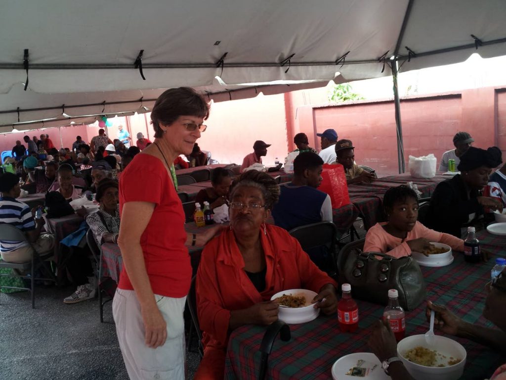 HELPING HAND: Rosemary Scott, left, assistant director of Living Water Community, greets people who came for a meal yesterday.
PHOTO BY JELANI BECKLES 