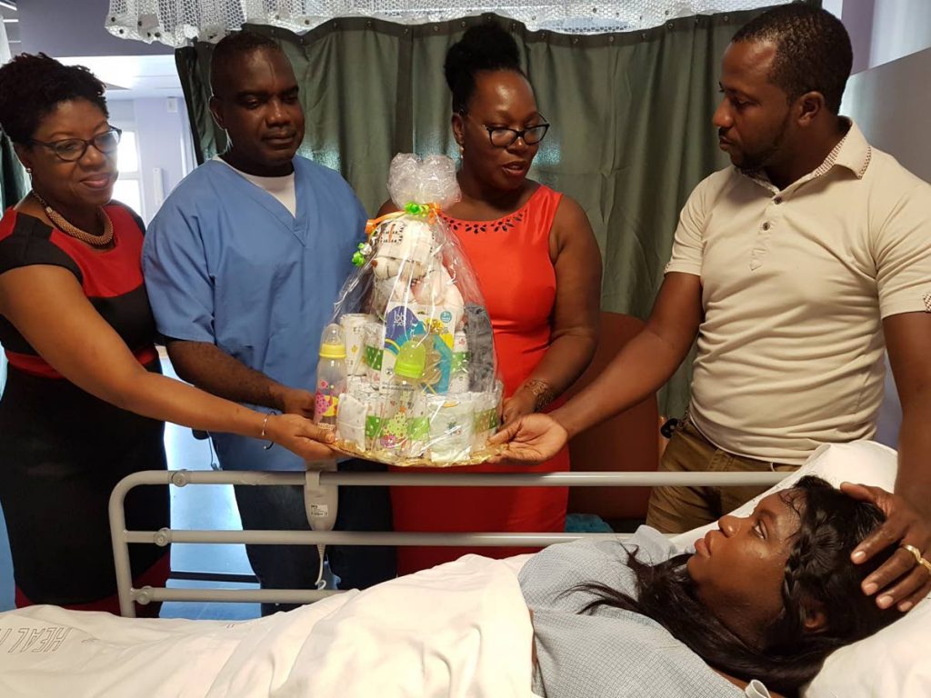 First-time parents: (Left to right) Acting secondary care nurse manager Sarah Celestine-Balfour, acting medical chief of staff Dr Ogonna Okeke and acting CEO Tobago Regional Health Authority (TRHA) Michelle Edwards-Benjamin congratulate Kirby James and Akimbar Grant-James on the birth of their daughter at Scarborough General Hospital on Christmas Day. PHOTO COURTESY TRHA