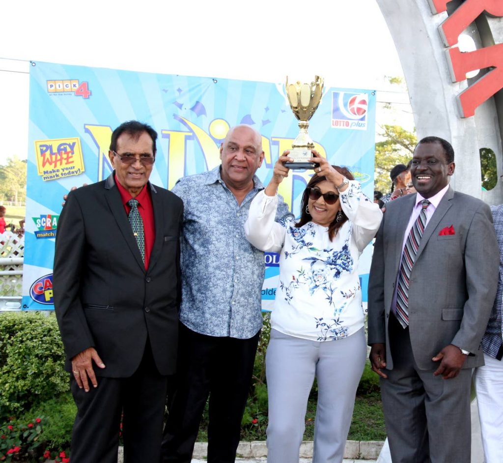 Kama Maharaj (second from right) and his wife Kamla (second from right) hold up the NLCB Gold Cup, wih a smiling NLCB director Selby Browne (right) and ARC president Baskaran Basssawh looking on.