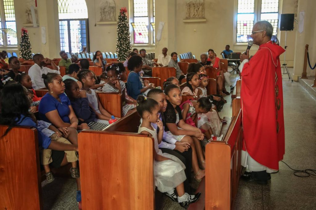 BLESS THEM Fr Martin Sirju gives the homily at the Holy Innocents Mass, Cathedral of Immaculate Conception, Port of-Spain yesterday.