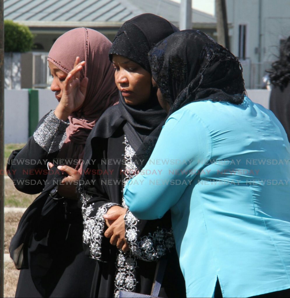 (Centre) Chimene Pantin, mother of Joash Pantin, is comforted by mourners gathered at the burial site, as the final dua prayer was being performed after laying the coffin of Joash Pantin at Monroe Road Muslim Cemetery.

Photo: Roger Jacob