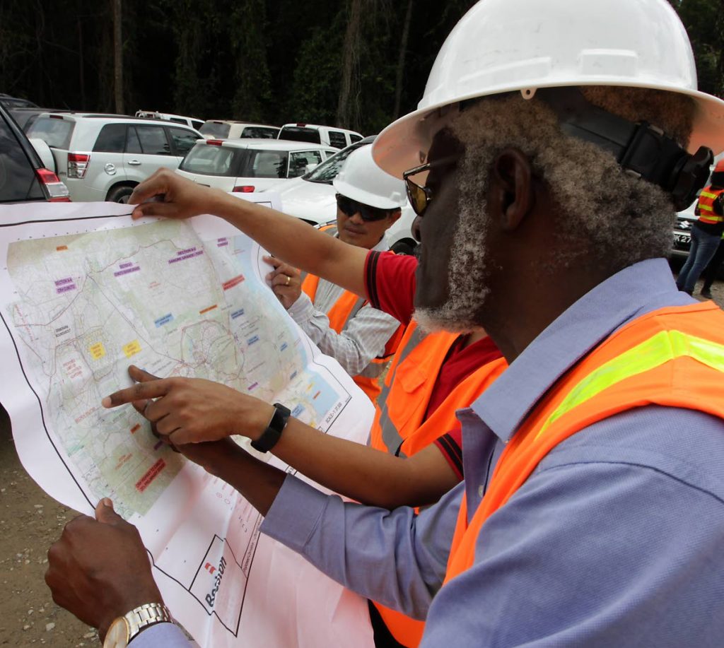 In this April 7, 2018 file photo Nipdec chairman Herbet George, left, and Works and Transport Minister Rohan Sinanan, far right, are shown a map of the Cumuto/Manzanilla Highway project during a site visit at Trainline, Cumuto. PHOTO BY ROGER JACOB 