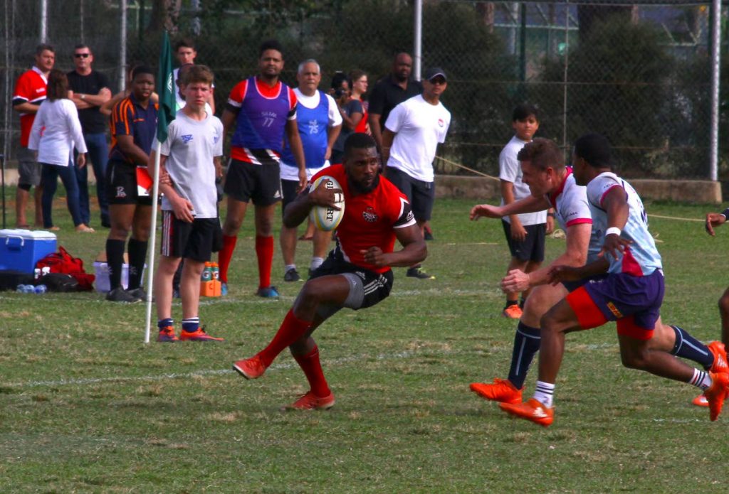 TT's James Phillip, left, looks to escape the tackle of two Bermuda players in a Rugby Americas North Men's 15s Championship game last year. PHOTO BY ROGER JACOB 