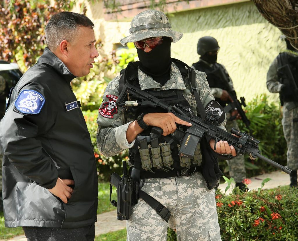 Police Commissioner Gary Griffith and a special operations officer at a crime scene in Port of Spain last December.