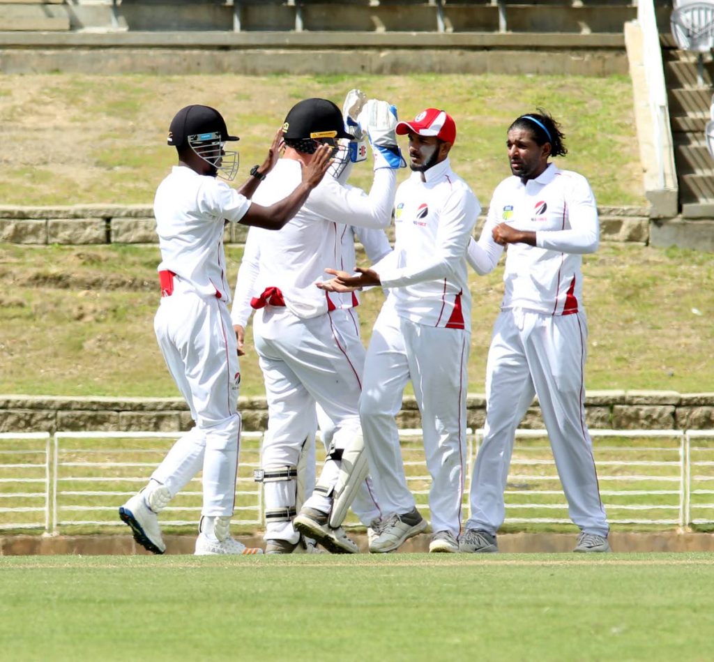 Red Force captain Imran Khan, right, celebrates one of his seven wickets with his teammates on day one of their clash with Windward Islands on Dec 13, at Brian Lara Academy, Tarouba. Red Force face the Windward Islands tomorrow at the same venue.