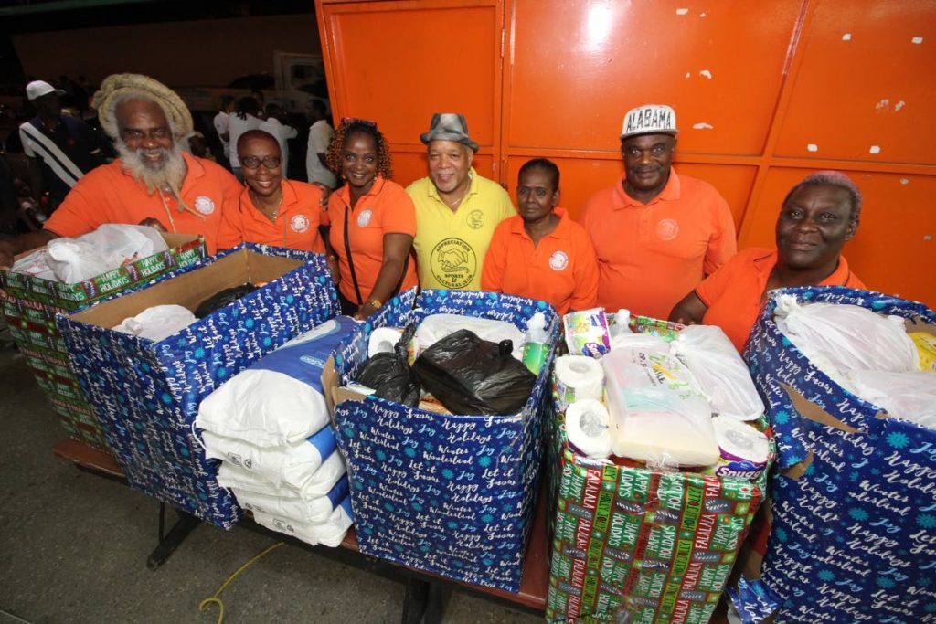 ALL-FOURS CHARITY DRIVE: The Appreciation Sports & Cultural Club executive committee including (from left) president Stafford Pierre, vice-president Donna Nanton, Marceline Modeste, Garth Dolldron, Merle Sookram, David Lewis and Karen Lyndsay distribute Christmas hampers at the launch of Angostura Fairplay League, Yellow Bird Bar, Eastern Main Road, Laventille, last month. PHOTO BY ROGER JACOB