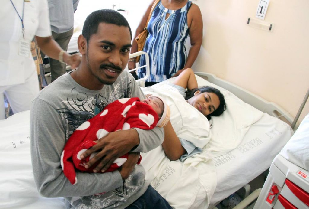 Mark Moona holds his new born baby girl yesterday for the first time, while mom Anna Khan, looks on. PHOTOS BY SUREASH CHOLAI