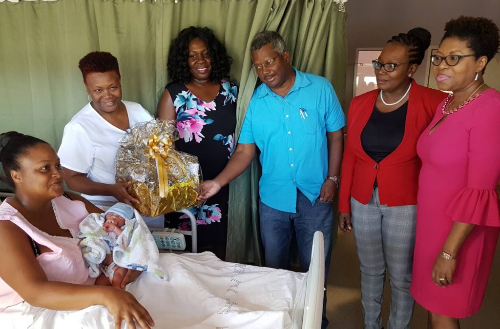 Juanita Gumbs, who gave birth to a baby on New Year’s Day at the Scar borough General Hospital, is presented with a hamper by staff at the hospital and the Tobago Regional Health Authority officials, from left, midwife Beverly Baptiste, TRHA Chairman Ingrid Melville, acting Medical Chief of Staff, Dr Victor Wheeler, acting TRHA CEO Michelle Edwards-Benjamin and acting Secondary Care Nurse Manager Sarah Celestine Balfour, at the Maternity Ward of the hospital.