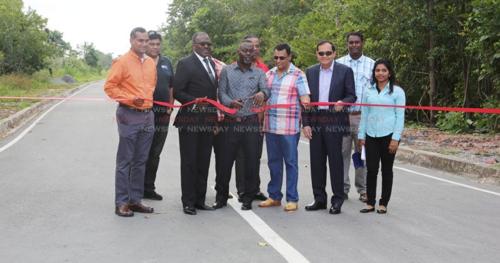 Pt Fortin Mayor Abdon Mason cuts the ribbon to open Richardson Road Extension, Pt Fortin alongside, from left, Coosal's operations Glen Mahabirsingh, engineer Navin Ramsingh, Point Fortin MP Edmund Dillion, Works and Transport Minister Rohan Sinanan, Coosals Group chairman Sieunarine Coosal and representatives of PURE and Coosals.  PHOTO BY VASHTI SINGH