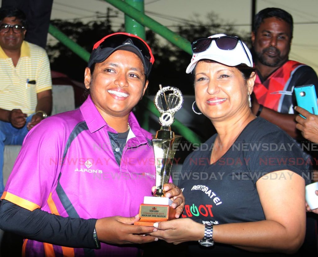 West Indies women's spinner Anisa Mohammed, left, is presented with a trophy by a Reboot representative for being the best bowler at the Daren Ganga Foundation charity T20 match on Saturday in Barrackpore. PHOTO BY VASHTI SINGH