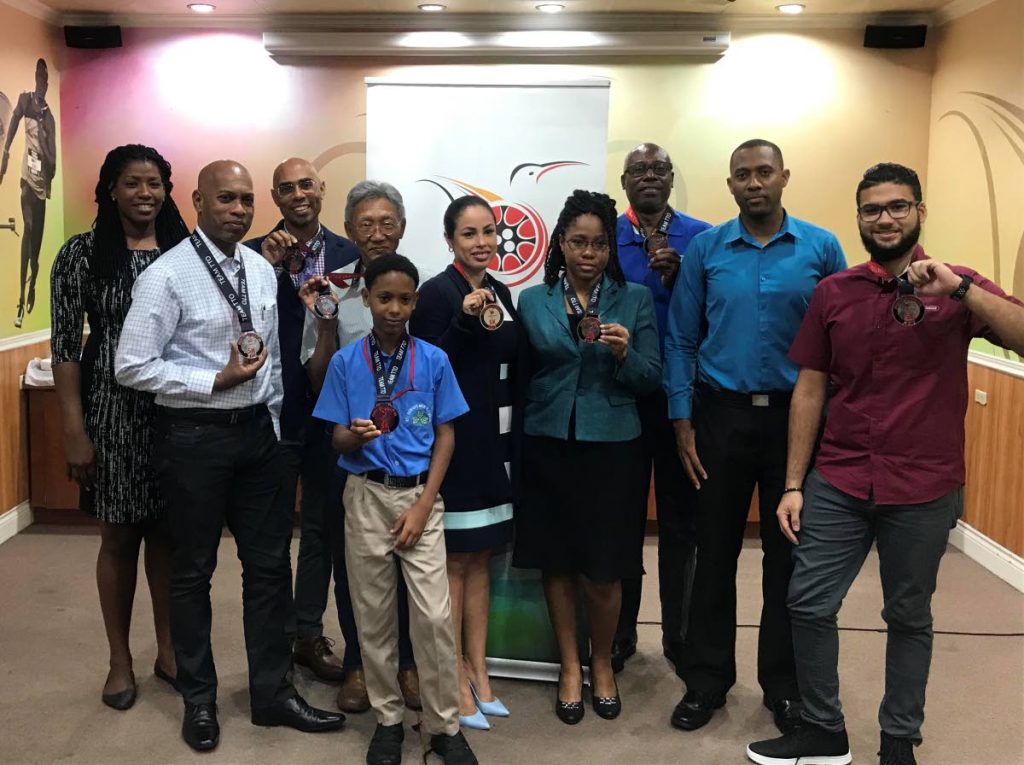 Runners, who completed the BAFA Sports/TTOC Virtual 5K, pose with their medals during a distribution ceremony at TTOC Olympic House, Abercromby St, Port of Spain, yesterday. 