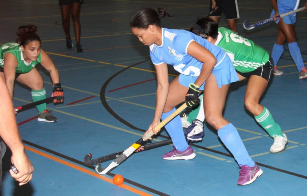 UWI's Keidi Braithwaite, centre, is tackled by Ventures' Rose-Anne Reyes, right, in the UWI Invitational Indoor Hockey Tournament on Thursday evening at UWI-SPEC, St Augustine. PHOTO BY ANGELO MARCELLE 