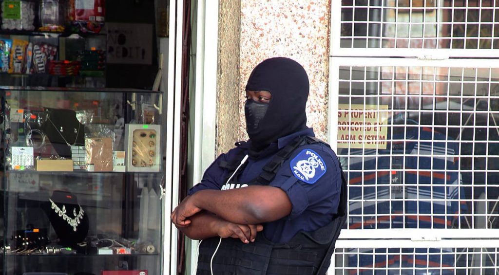 Despite a financial squeeze on the Police Service with Government only releasing funds to pay salaries, officers continue to do their duty including this one who stood guard yesterday near the Port of Spain Magistrates Court while high-risk prisoners were being escorted to the courthouse.