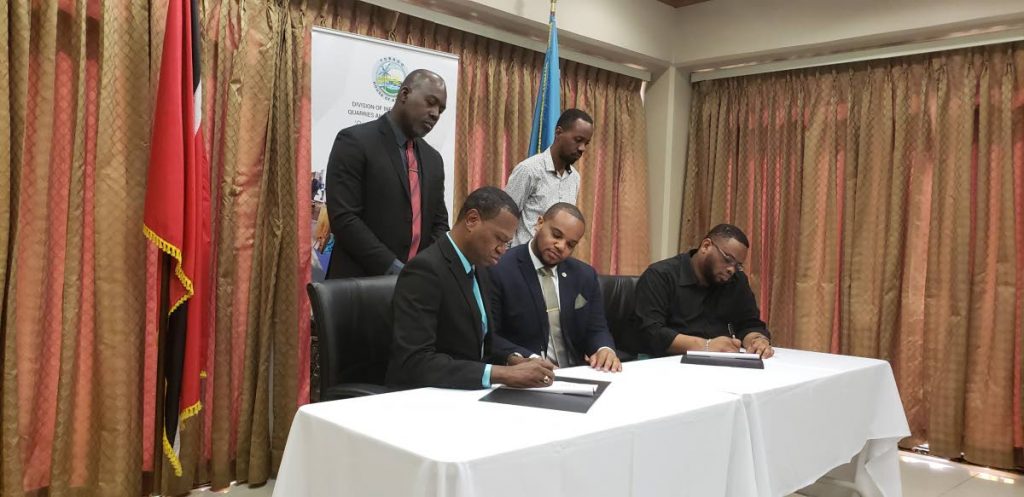 From left, Elroy Julien, Chief Executive Officer of the National Commission for Self Help Limited, Kwesi Des Vignes, Secretary of the Division of Infrastructure, and Ritchie Toppin, Administrator in the Division, sign off a Memorandum of Understanding between the Commission and the Division on Friday. Looking on are Julian Celestine, Senior Poject Officer with the Commission and Reyon John, Executive Assistant to the Division’s Administrator.  