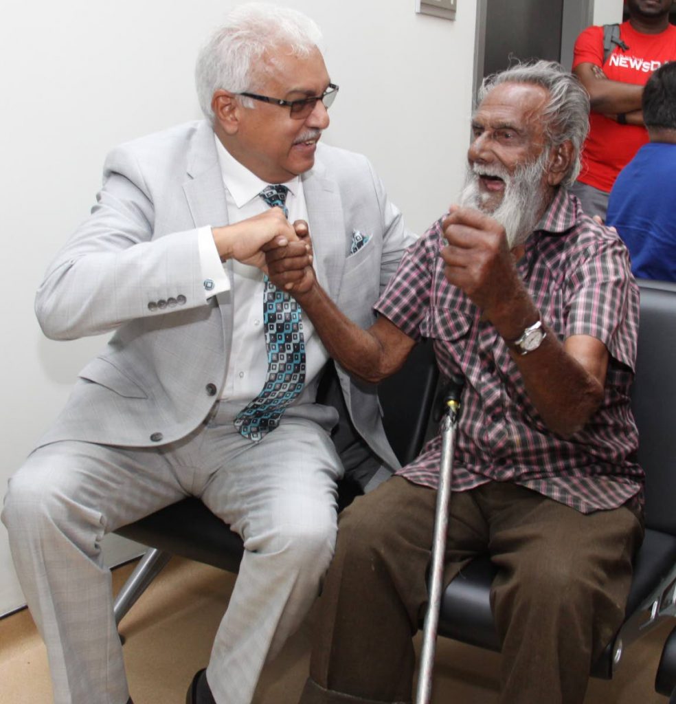 Hafic Ali, 92, tests his strength against Health Minister Terrence Deyalsingh at the opening of the Sangre Grande Enhanced Health Centre, Sangre Grande yesterday.