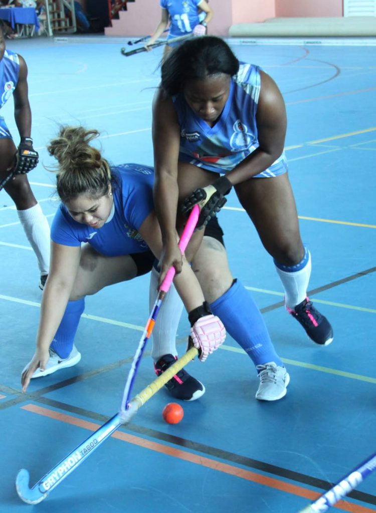 UWI’s Blair Obrien,left, receives a strong challenge from Antonia Gordon of Police, during their match up in the, UWI 2nd Invitational Indoor Hockey tournament, at UWISPEC, St. Augustine, yesterday.

Photo: Angello Marcelle
