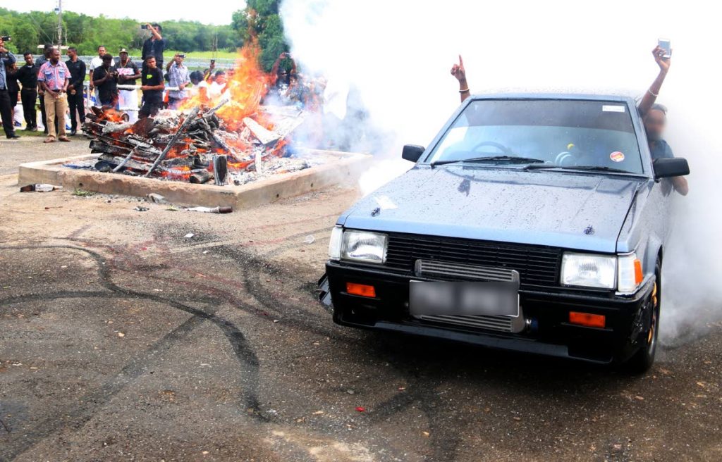 NO RESPECT: Men perform stunts in a car near a burning funeral pyre last week at the Shore of Peace cremation site in Mosquite Creek. FILE PHOTO