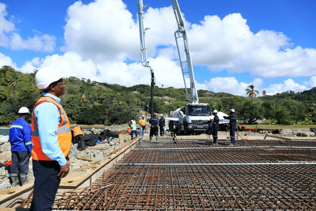 General Manager of the Studley Park Enterprise Limited (SPEL), Dexter East, looks on as workmen get the cement pump going at the Barbados Bay jetty rehabilitation project at Studley Park on Monday.
