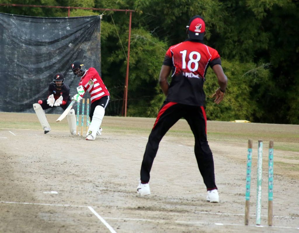 Jason Mohammed drives a delivery from spinner Khary Pierre as wicketkeeper Amir Jangoo looks on yesterday, during a training session at the National Cricket Centre, Couva. PHOTO BY VASHTI SINGH