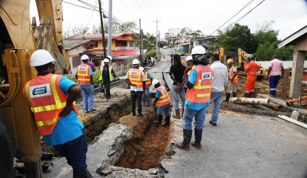 File photo: WASA workers repair a ruptured water line at Indian Walk, Moruga yesterday where a part of the road collapsed on Tuesday night.  PHOTO BY LINCOLN HOLDER