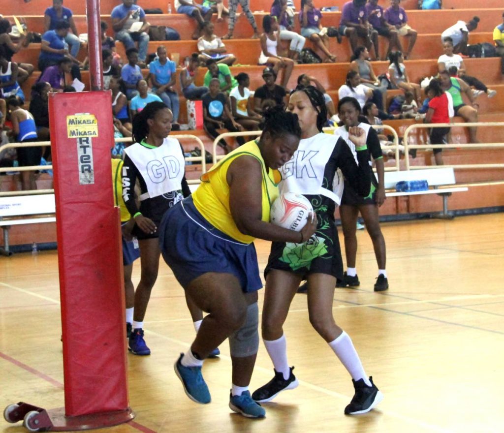 A Defence Force player grabs the ball under pressure from her TSTT rival in a Courts All Sectors Netball League championship division match last Saturday at the Eastern Regional Indoor Arena, Tacarigua. PHOTO BY SUREASH CHOLAI 