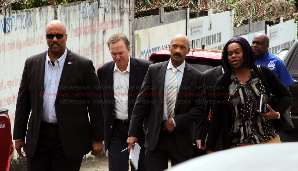 (at right) A female police officer leads a delegation of foreign nations to the murder scene of the latest homicide where Kias James was shot dead, Lady Hochoy Road, Cocorite.

Photo: Roger Jacob