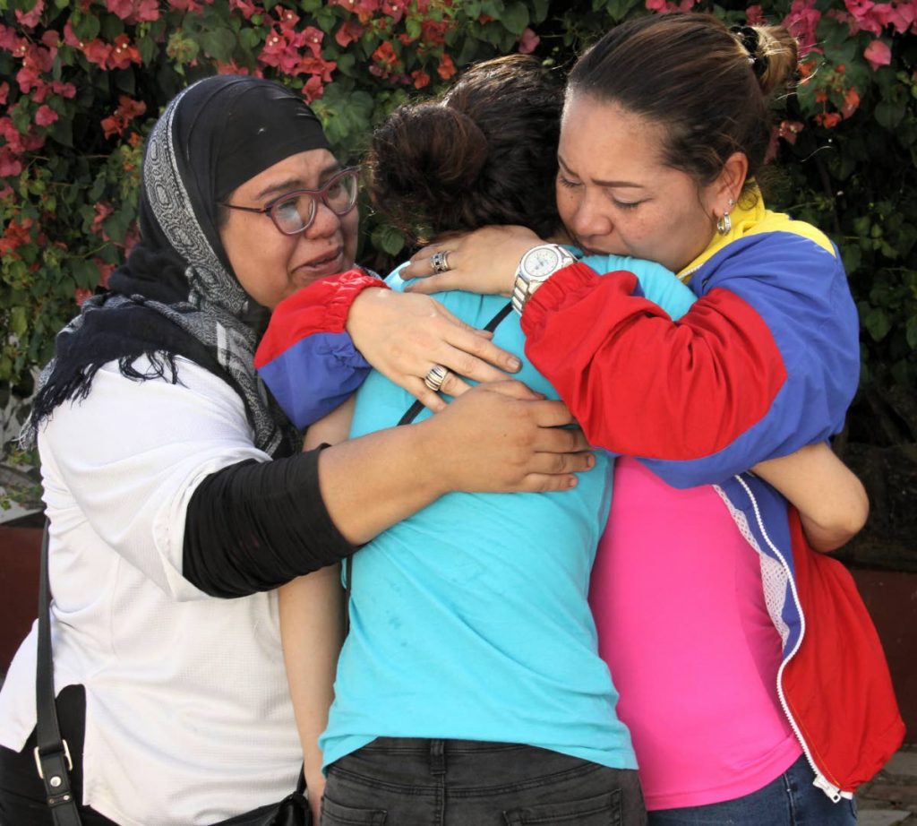 Dexis Carolina Rosas, centre, is embraced by Martha Tovar, left, and Carolina Gomez at a press conference held in Mt Lambert to highlight the plight of Venezuelan and other refugees on January 18.    PHOTO BY ANGELO M  MARCELLE