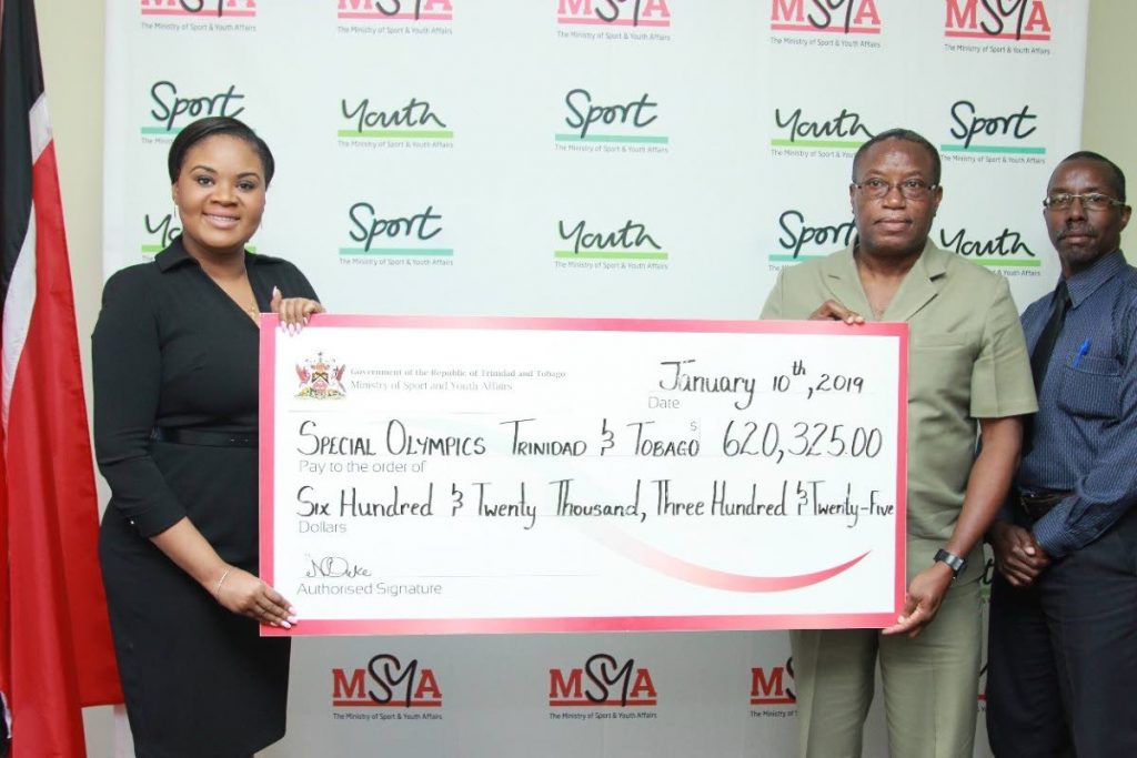 Sports Minister Shamfa Cudjoe, left, presents a cheque to Special Olympics TT national director Ferdinand Bibby, as Patrice Charles, the sports ministry's director of physical education and sport looks on. 

