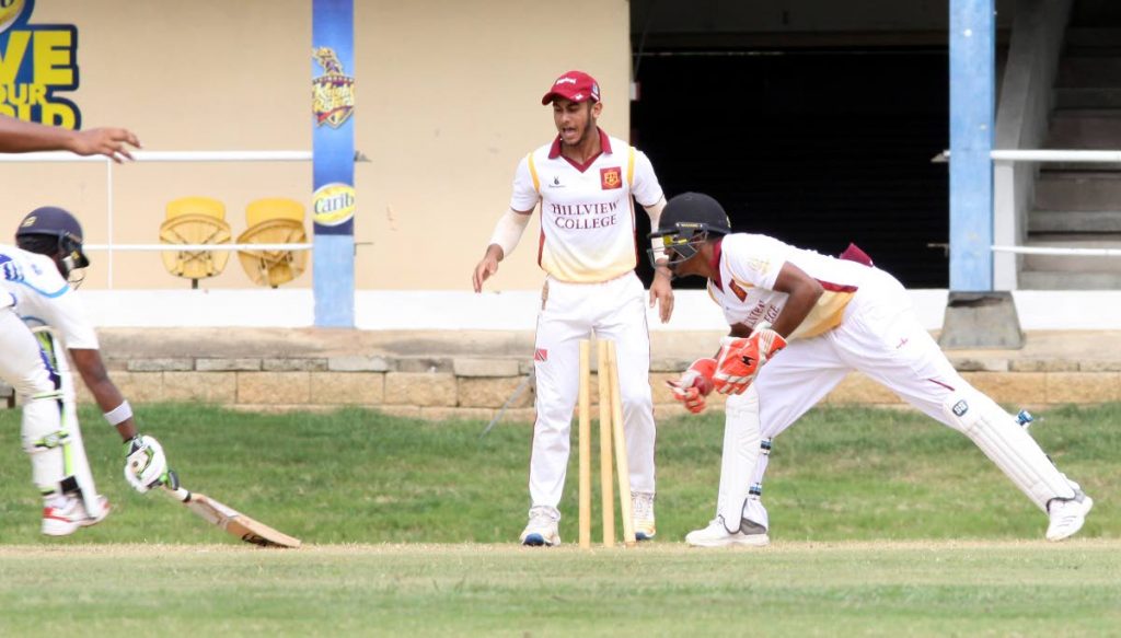 Hillview wicketkeeper Leonardo Julien,right, successfully runs out a Naparima player, during the Secondary Schools Cricket League opener, at the Queen’s Park Oval, St Clair, yesterday.