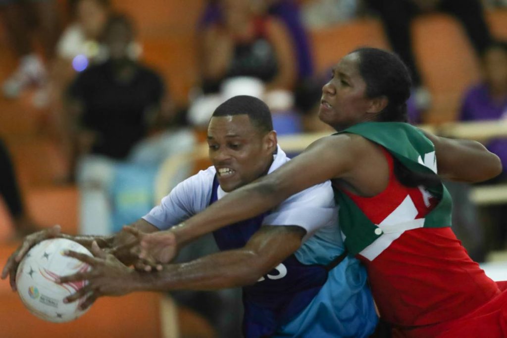 Police's wing-attack Steve Mc Sween, left, receives a pass while defended by Fire's goalkeeper in a Courts All Sectors Netball League match recently at Eastern Regional Indoor Sports Arena, Tacarigua. PHOTO BY KERLON ORR/CA-IMAGES 