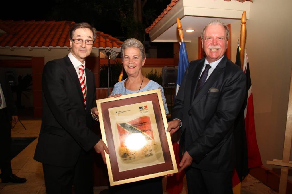 Rhonda Maingot, Co-Foundress of Living Water Community receives the Franco-German Prize for Human Rights and the Rule of Law on behalf of her organisation presented  by the German ambassador Holger Michael, right, and French ambassdor Serge Lavroff, left, the German ambassor residence on Scott Street in St Clair on Tuesday. PHOTO SUREASH CHOLAI