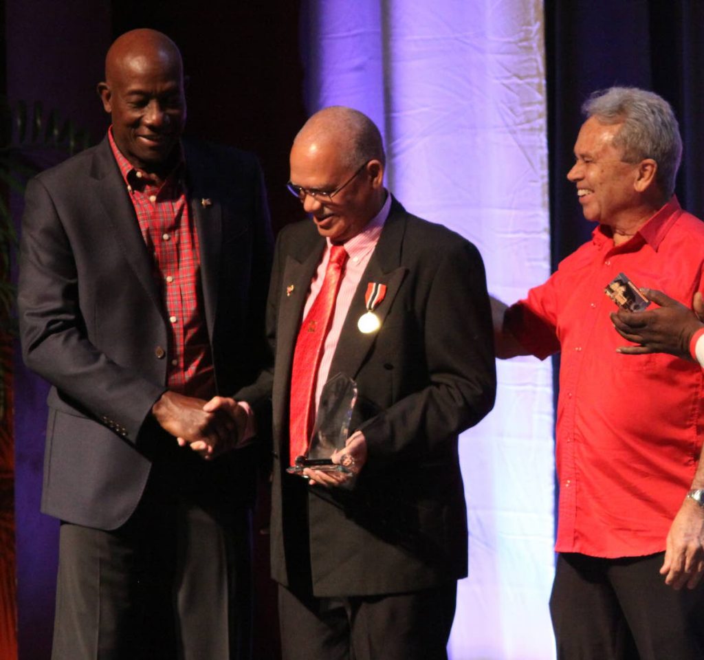 Prime Minister Dr Keith Rowley and Colm Imbert, PNM chairman and Finance Minister, congratulate stalwart Ashton Ford during the party's 63rd anniversary celebrations at NAPA, Port of Spain yesterday. PHOTO BY ANGELO MARCELLE