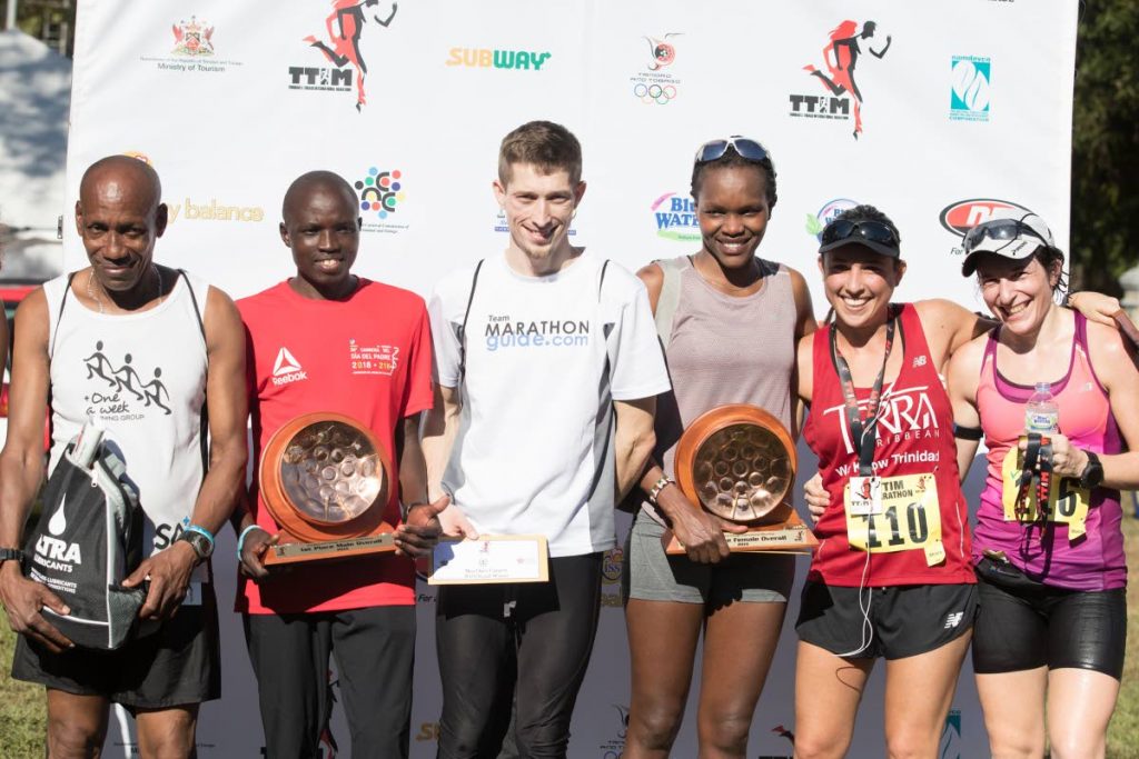 (L-R)Cantius Thomas, the first Trinidadian to cross the finish line stands next to overall winner Kenyan Stephen Njoroge Mbure, second placed Bryan Morseman, of the USA, first female winner Grace Kahura, first Trinidadian female Sjaelan Evans and third placed female runner Allie Adam after they competed at the TT International Marathon yesterday.