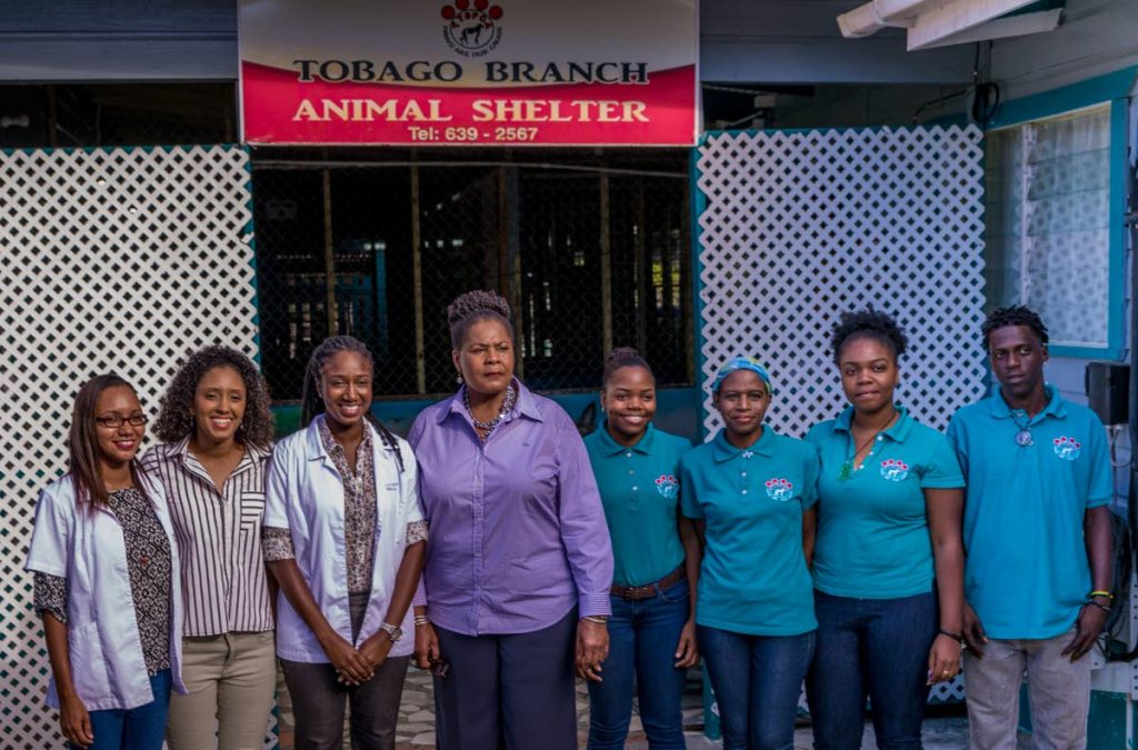 President Paula Mae-Weeks poses for a photo with staff of the Tobago animal shelter (TTSPCA) at Friendsfield Branch Rd in Scarborough Calder Hall during a tour on Tuesday. Photo by David Reid