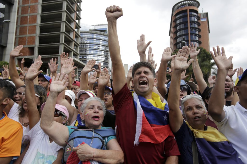 Anti-government protesters cheer after Juan Guaido, head of Venezuela's opposition-run congress, declared himself interim president of the South American country until new elections can be called, at a rally demanding the resignation of President Nicolas Maduro, in Caracas, Venezuela. (AP Photo/Boris Vergara)
