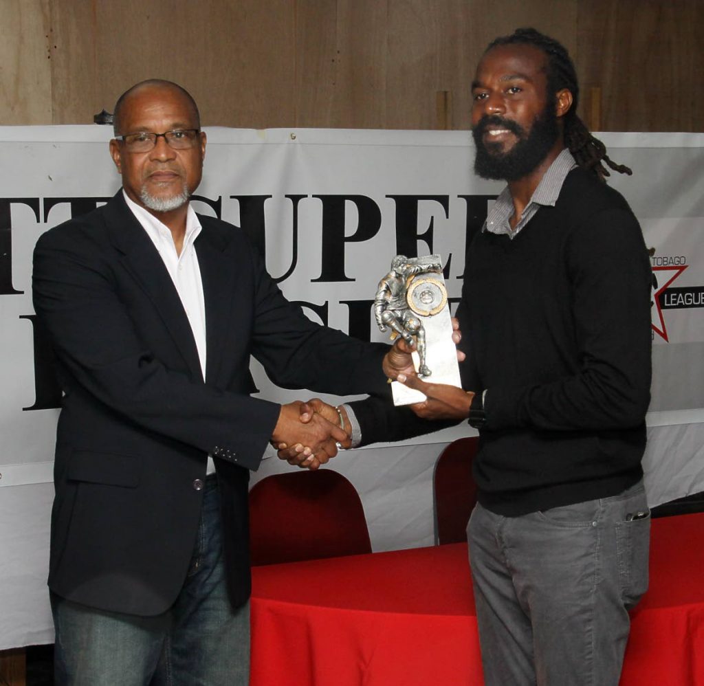 Super League president Keith Look Loy, left, presents the MVP award to Queen's Park defender Yohance Marshall at the league's awards ceremony at WASA Sports Club, St Joseph, last year. PHOTO BY ANGELO MARCELLE  