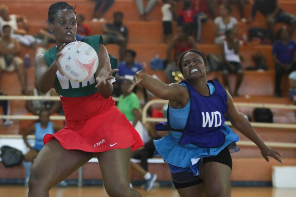 In this Jan 19 file photo, Fire’s Wing Attack Ornella Jack Hill,left,receives a pass ahead of Police’s (blue bib) Wing Defence Stacy Pilgrim during the Courts All Sectors Netball League between Police and Fire Service at Eastern Regional Indoor Facility, Tacarigua.