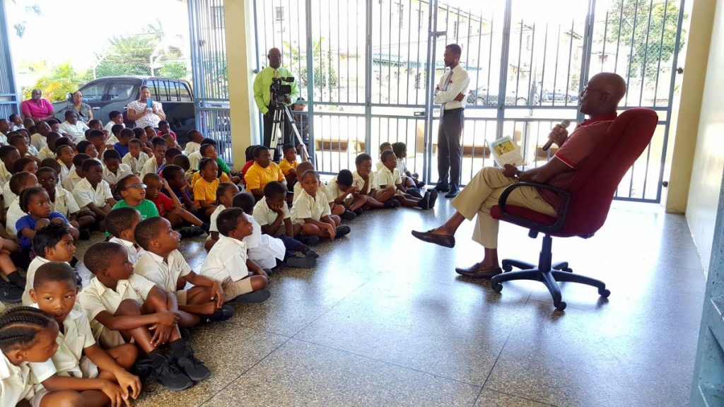Prime Minister Dr Keith Rowley reads to students at the Carenage Government Boys School yesterday as part of World Read Aloud Day. PHOTO COURTESY THE OFFICE OF THE PRIME MINISTER