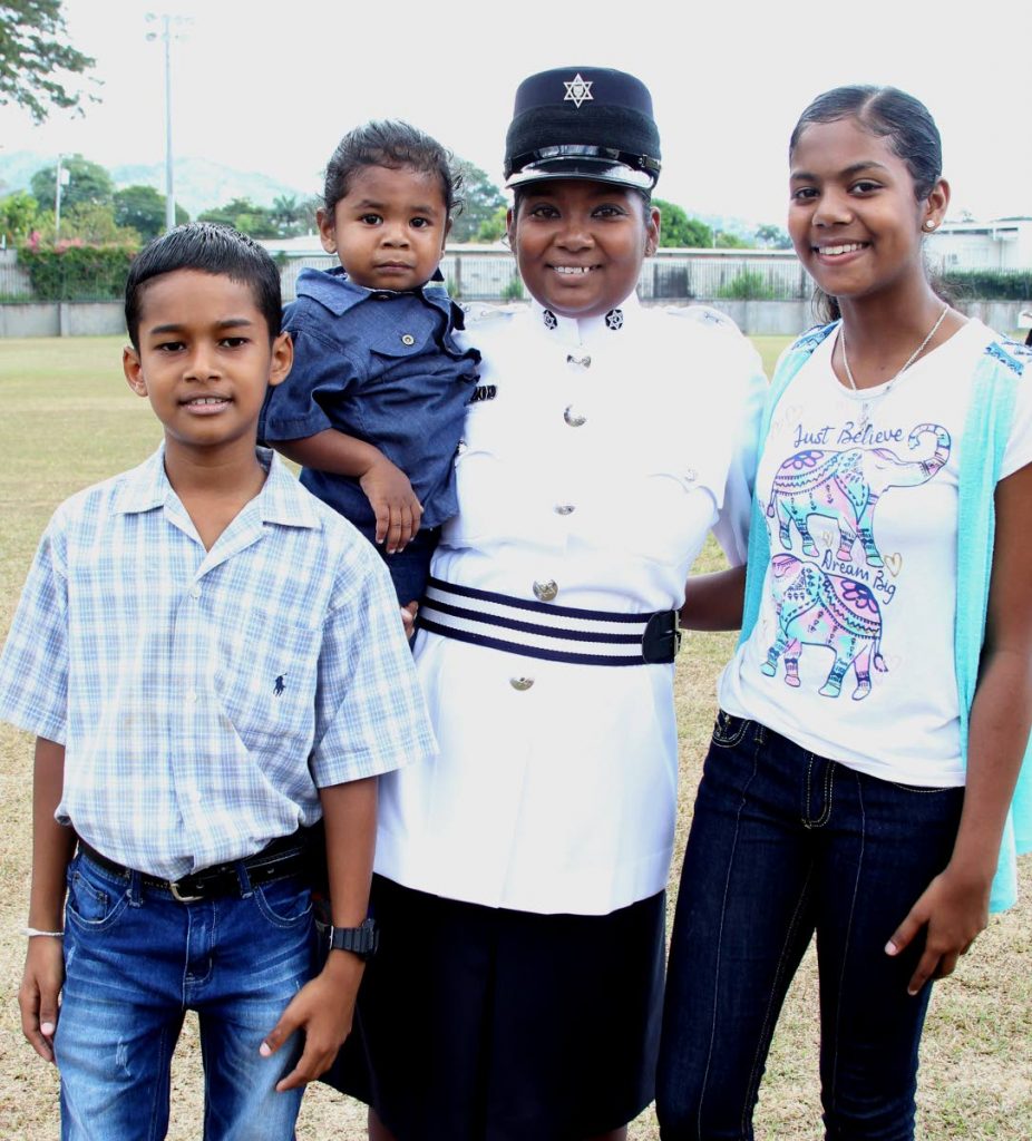  Natasha Gopee shares the proud moment she became a municipal police constable with her children Danesh, two, and Nandini, 13, and nephew Tristan, 10, after the passing out parade for municipal officers at the Police Academy, St James yesterday. 