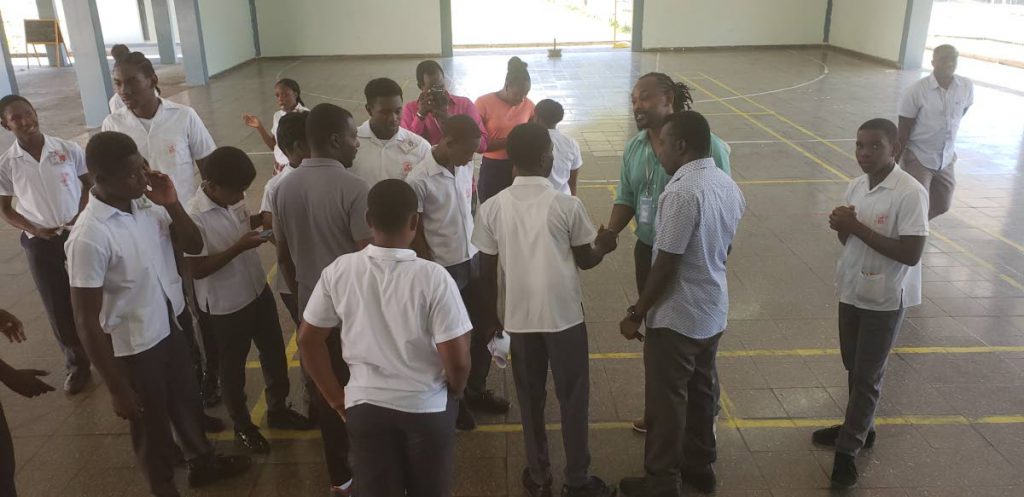 Former defender with the national football team, Brent Sancho, in green shirt, engages students of Mason Hall Secondary School during Monday’s Career in Sports Caravan hosted by the THA Division of Sport and Youth Affairs.