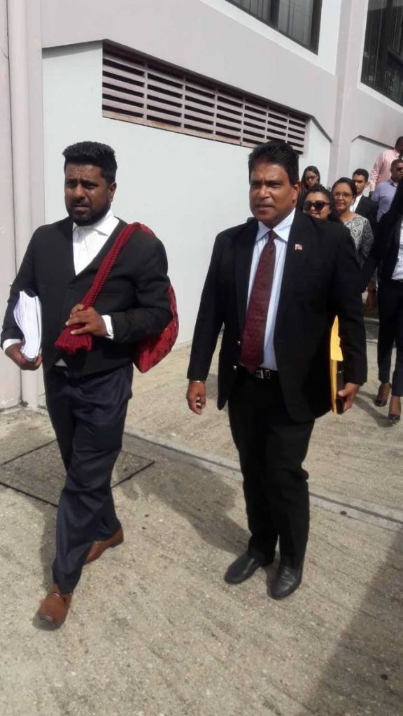 Oropouche East MP Dr Roodal Moonilal leaves San Fernando High Court yesterday with his attorney Gerald Ramdeen. Members of his constituency are in the background