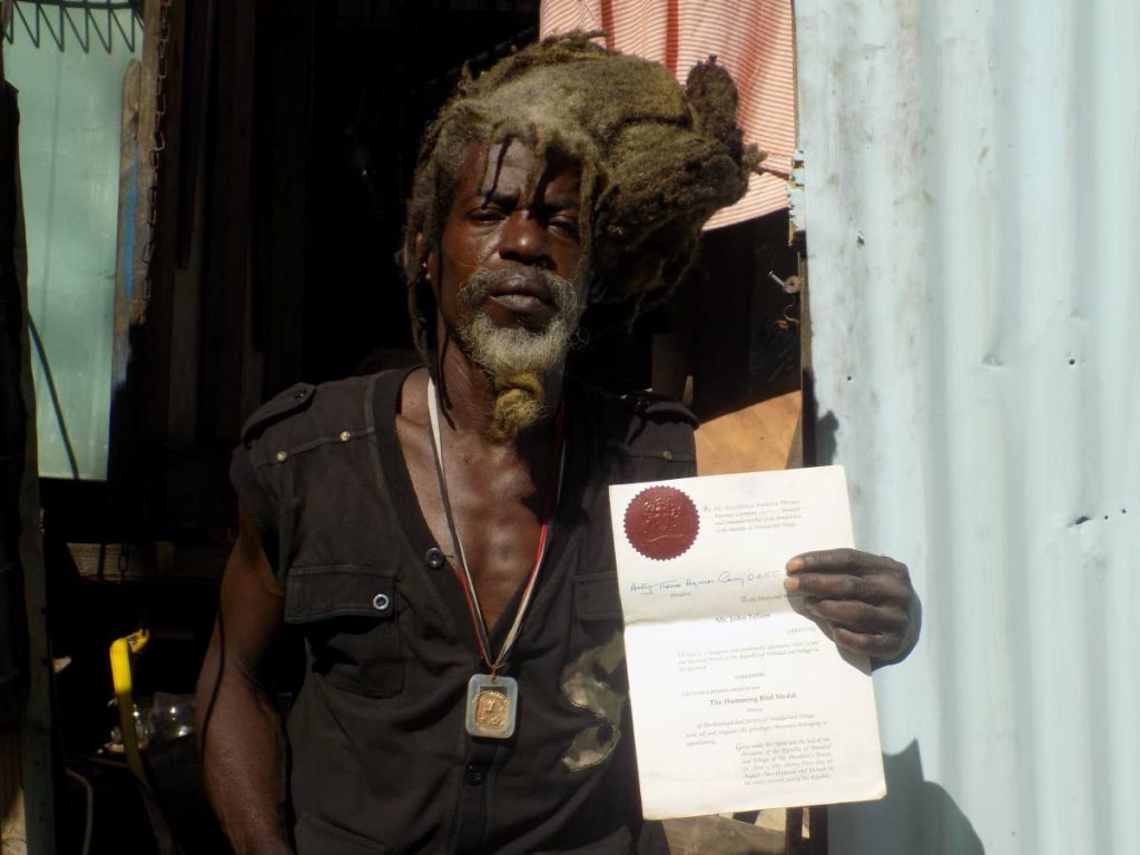 John Julien, 57, shows a document cerifying him as the recipient of a Hummingbird Bronze Medal for bravery. He was awarded the medal for rescuing a newborn baby that was left abandoned in a dumpster in 2013. 
Today he is struggling with keeping a roof over his head. 


Photo:  Shane Superville
