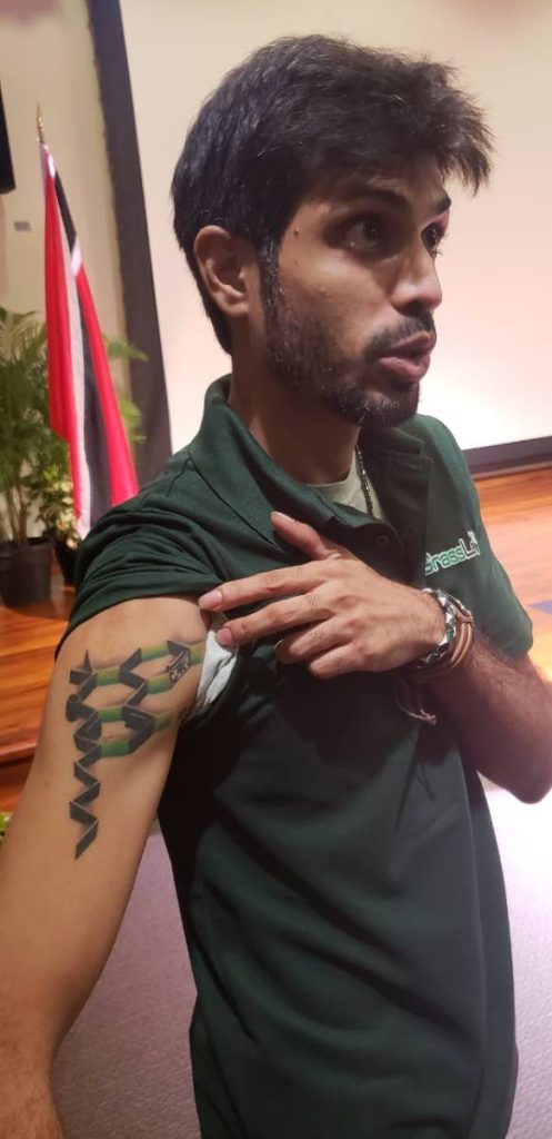 Javed Baksh, owner of GrassLab, shows a tattoo of a THC molecule on his arm at the Government's second marijuana consultation at UWI's St Augustine campus on Wednesday. Baksh used to experience psychotic episodes where he would cut himself and try to commit suicide. He credits cannabis for helping his condition. PHOTO BY RACHAEL ESPINET