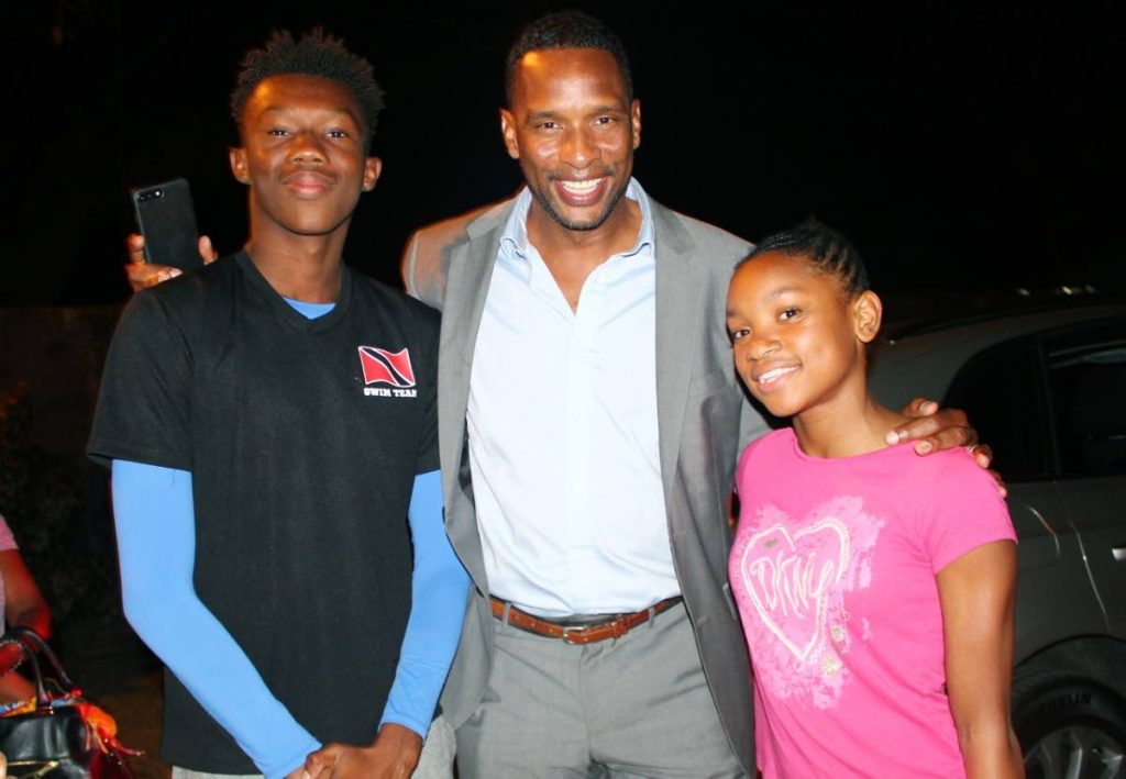 Shaka Hislop, centre, shares a light moment with two Flying Fish Swim Club members.