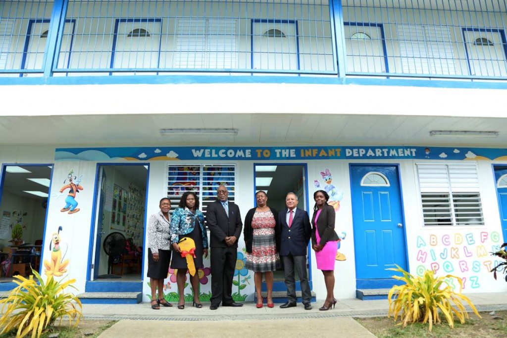 Chief Secretary Kelvin Charles, third from left, and Chris Jagroop, second from right, acting Chief Executive Officer, Udecott, stand in front of the newly constructed annex at Whim Anglican on Tuesday. Others in photo are from left, Karen Boatswain, School Supervisor II, Division of Education, Christine Benoit, Principal of Whim Anglican, Jacqueline Job, Administrator, Division of Education, and Janelle Berkley of Udecott.