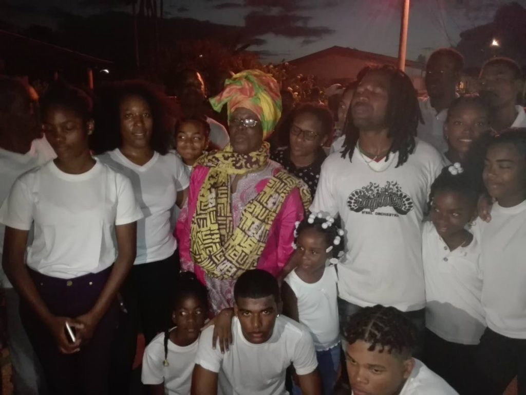 Jay Notes members with cultural icon Ella Andall, centre, at their pan tent on Guy Street, Sangre Grande, Thursday. 