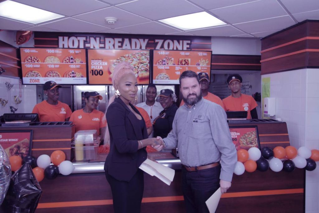 Soca singer Partice Roberts shakes hands with Rafael Moraga, the regional manager of Restaurant Holdings Limited (franchisees of Burger King, Popeyes and Little Caesars Pizza throughout the Caribbean). Roberts is now Little Ceasars brand ambassador.